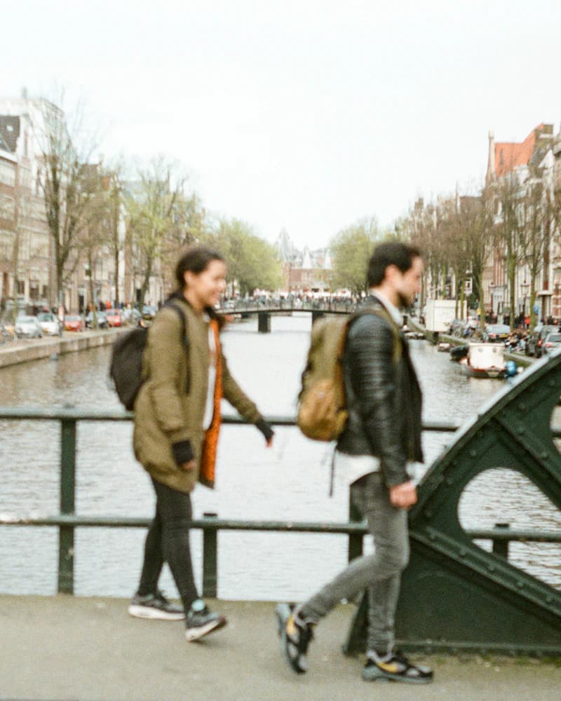 Un homme et une femme qui traversent un pont au-dessus d'un canal