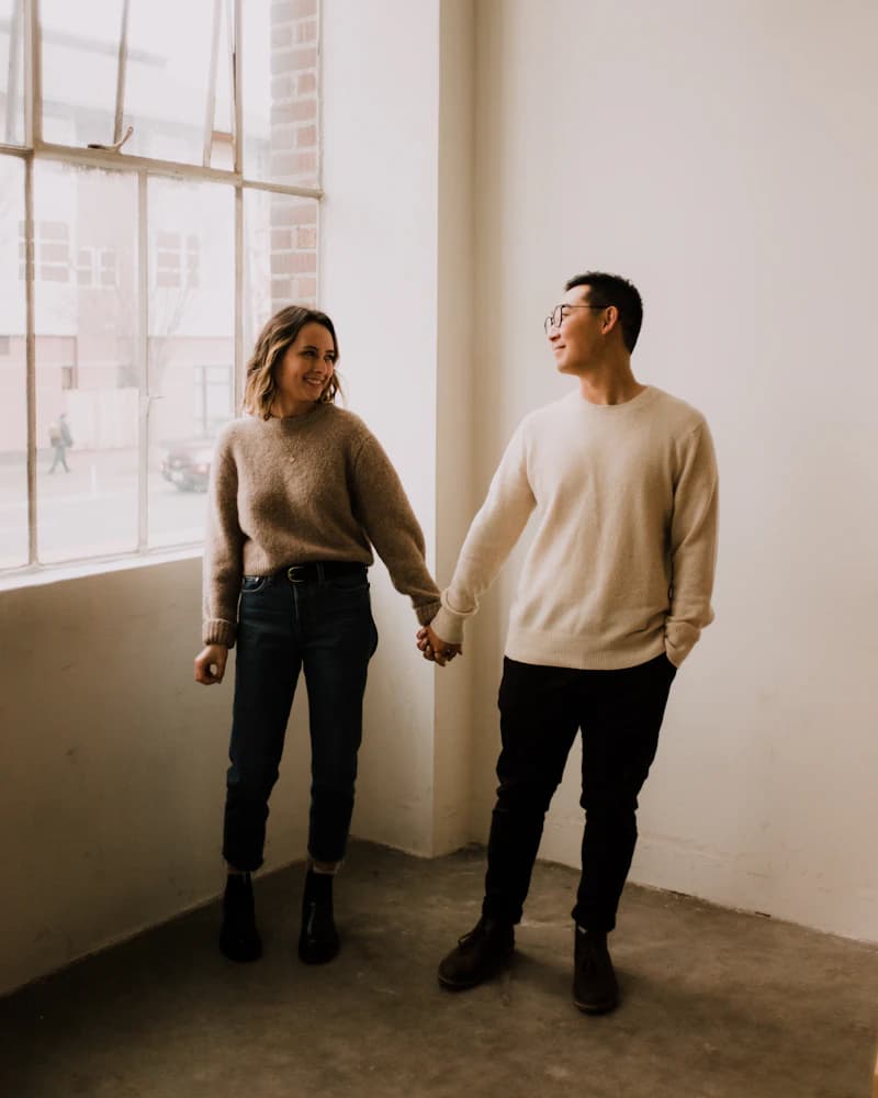 Un homme et une femme qui se tiennent la main près d'une fenêtre